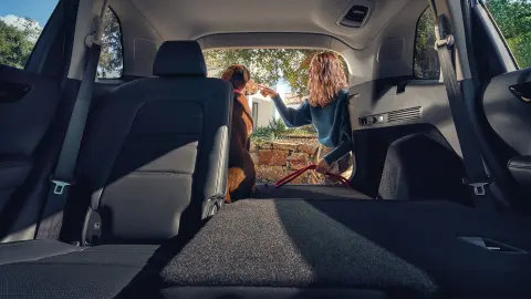 CR-V Hybrid SUV – sklopené zadní sedadlo, žena a pes v otevřeném zavazadlovém prostoru 