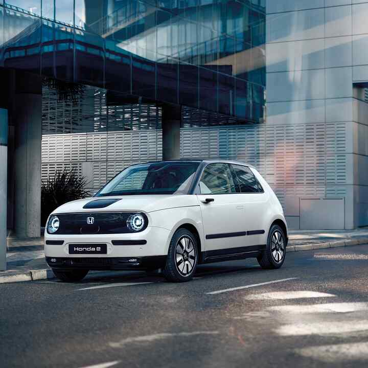 Honda e na ulici s budovami v pozadí