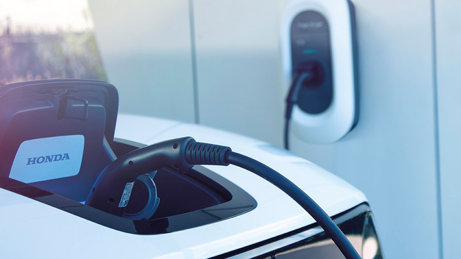Detailní záběr nabíječky napájecího zdroje Honda Power Charger v nabíjecí stanici.