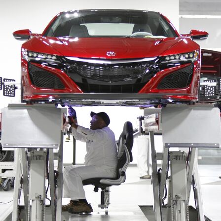 Pohled zepředu na vůz NSX, na kterém pracuje mechanik společnosti Honda