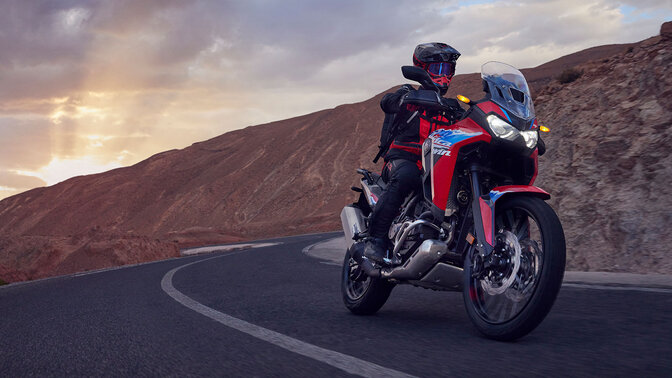 Figurant jedoucí na motocyklu CRF1100L Africa twin na silnici v horách