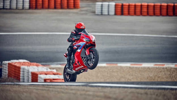 Osoba řídící motocykl stojící v blízkosti přechodu pro chodce na ulici.