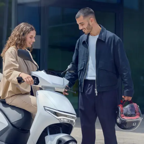 Figuranti sledující skútr Honda CUV e: ve městě